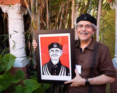 CRLA Executive Director Jose Padilla holds portrait created by Lalo Alcaraz September 2022