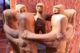 clay sculpture of people embracing in a circle