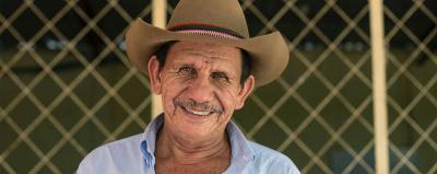 A man in a hat smiling.