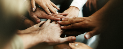 Hands in the middle of a team huddle.