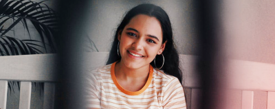 A woman on a bench smiling.