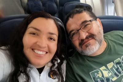 Selfie photo of two people smiling while seated on an airplane