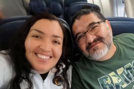 Selfie photo of two people smiling while seated on an airplane