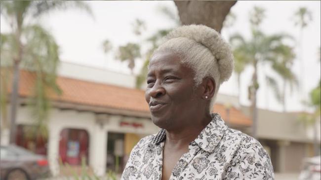 CRLA Oxnard client smiles with buildings and palm trees in background