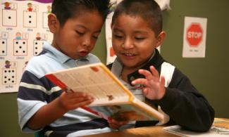 photo of two students reading a book