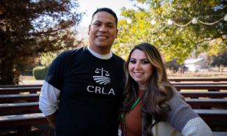 Two CRLA staff members smile at camera with trees in background