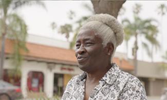 CRLA Oxnard client smiles with buildings and palm trees in background