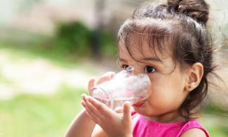 Child holding and drinking cup of water